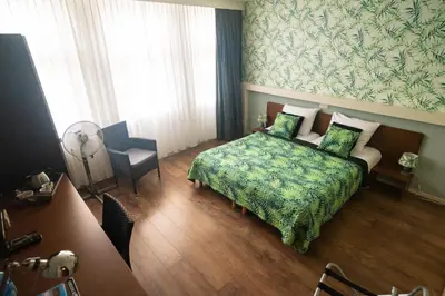 a hotel room with a bed and a chair at B&B Posthoorn in Hoorn