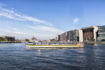 a boat filled with people on a river with buildings at AmicitiA in Amsterdam