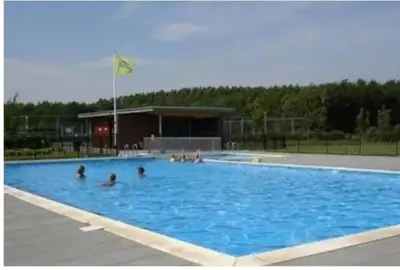 a group of people in a large swimming pool at The Cosy Cottage for Comfort with Sauna and Hottub in Zeewolde