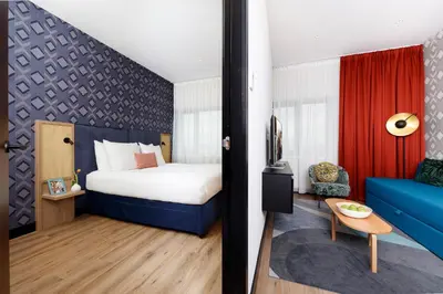 a hotel room with a bed and a blue couch at Boutique Apartments Amsterdam in Amsterdam