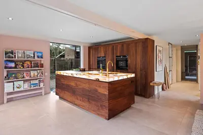a kitchen with a large wooden island with a sink at Villa in the forest near the beach in Bergen