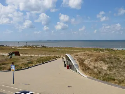 a sidewalk next to a beach with the ocean at Appartementen Zeezicht - 3 in Katwijk aan Zee