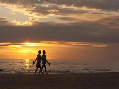 a couple walking on the beach at sunset at Apartment in Noordwijk near North Sea Beach in Noordwijk