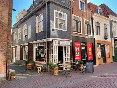 a building on a city street with tables and chairs at Tiny Private City Rooms Haarlem in Haarlem