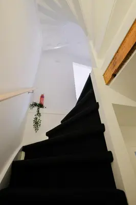 a staircase in a house with a black stair case at Tiny Private City Rooms Haarlem in Haarlem