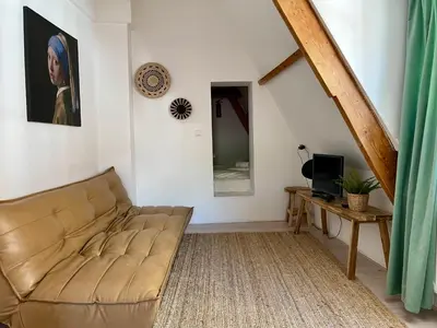 a living room with a couch and a television at Tiny Private City Rooms Haarlem in Haarlem