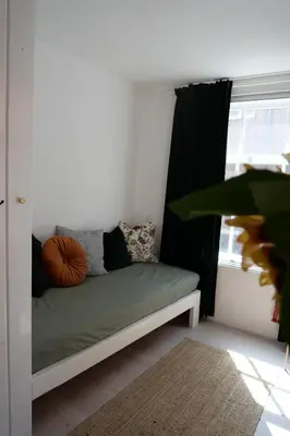 a bed sitting in a room with a window at Tiny Private City Rooms Haarlem in Haarlem