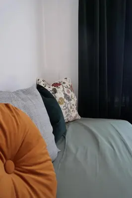 a bed with an orange pillow and two pillows at Tiny Private City Rooms Haarlem in Haarlem