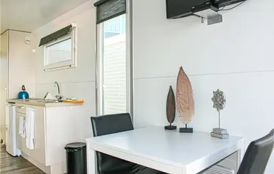 a kitchen and dining room with a white table and chairs at Madrid in Lelystad