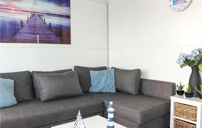 a living room with a gray couch with blue pillows at Madrid in Lelystad