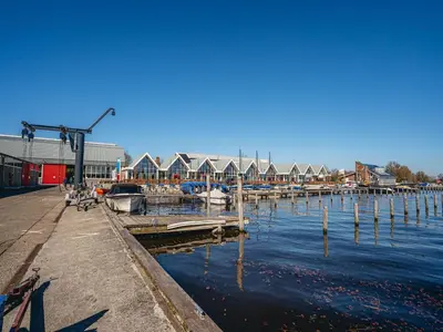 a marina with boats in the water and houses at Harbour Lodge at Uitgeestermeer View in Uitgeest