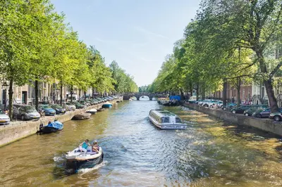 two people in a boat on a river with cars at B&B 1971 Hazenstraat - Shared Bathroom in Amsterdam