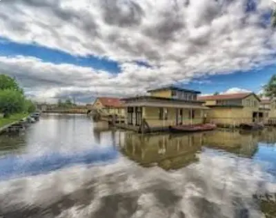 a view of a river with houses and buildings at Huisje Finn, met grote tuin en veel privacy in Dirkshorn