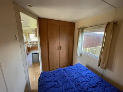 a bedroom with a blue bed and a window at Duindoorn 45 in IJmuiden