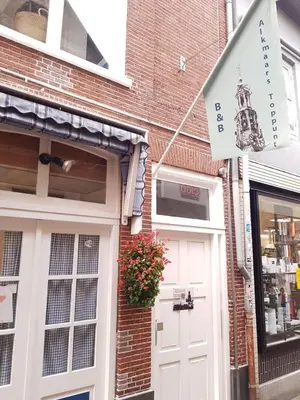 a building with a white door and a flag at B&B Alkmaars Toppunt XL in Alkmaar