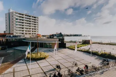 a building with bikes parked on a sidewalk near the beach at Sunny Spacious Apartment De Bijenkorf in Zandvoort