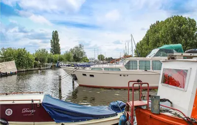 two boats are docked at a marina on the water at Huis Nr 2 in Woubrugge