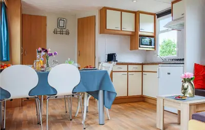 a kitchen and living room with a table and chairs at Huis Nr 2 in Woubrugge