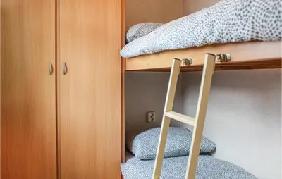 a bunk bed with a ladder next to a bunk bed at Huis Nr 5 in Woubrugge