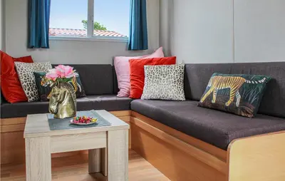 a living room with a couch with pillows and a table at Huis Nr 5 in Woubrugge