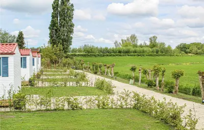 a garden with trees and a white building at Huis Nr 1 in Woubrugge