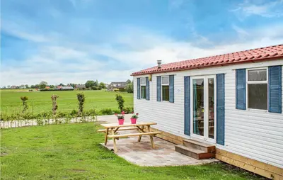 a small white cottage with a picnic table in the yard at Huis Nr 1 in Woubrugge