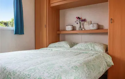 a bedroom with a bed with a green comforter and a window at Huis Nr 1 in Woubrugge