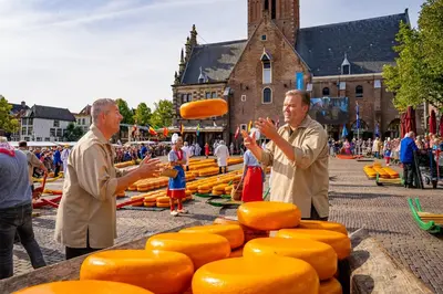 two men standing in front of a display of cheese at De Loft in Zuid-Scharwoude
