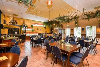a restaurant with tables and chairs in a room at Holiday-Chalet Westenwind 4p. Amsterdam & Beach in Opmeer