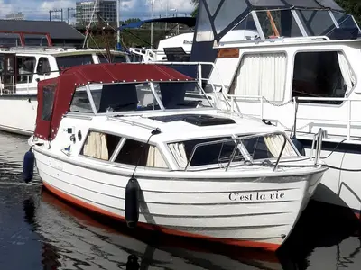 a white boat is docked in the water at Motor Yacht Amstelle in Amsterdam