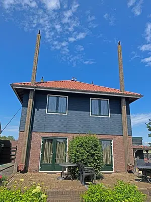 a house with two chimneys on top of it at Christinahoeve Hooiberg #6 in Boskoop