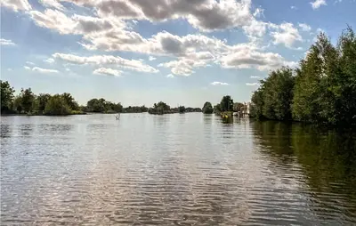a view of a river with trees and a cloudy sky at Lake Front Home In Breukelen in Breukelen