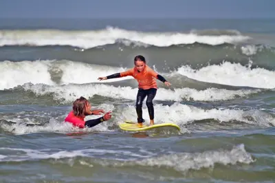 a young child riding a wave on a surfboard in the ocean at Villa Prinsenhof # Tweeëntwintig in Bergen