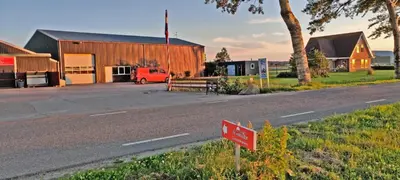 a red sign on the side of a road next to a building at Hotelhuisje Warmenhuizen #A in Warmenhuizen