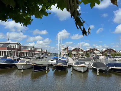 a bunch of boats docked in a marina with houses at Holiday Home Campi 400 by Interhome in Uitgeest