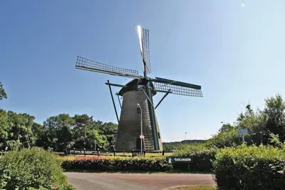 a windmill on the side of a road at Hotelhuisje Warmenhuizen #B in Warmenhuizen