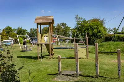 a park with a playground with a swing set at Chalet 536 op Recreatiepark De Wielen in Sint Maarten
