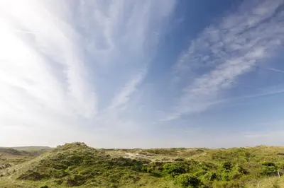 a view of some hills with a blue sky at Villa Parnassia in Bergen aan Zee