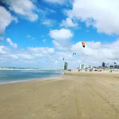 a group of people flying kites on the beach at Stop & Stay 1 in Zandvoort