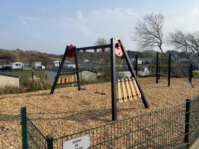 a swing set with bats on it in a park at Chalet Ibiza in de duinen van IJmuiden aan Zee in IJmuiden