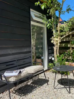 a chair and a table in front of a house at Holiday home De Heer van Bergen in Bergen