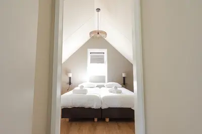 a bedroom with two beds and a window at Relaxen aan de kust by Droomvilla in Sint Maarten