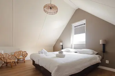 a white bedroom with two beds and a window at Ultiem genieten in Sint Maarten by Droomvilla in Sint Maarten