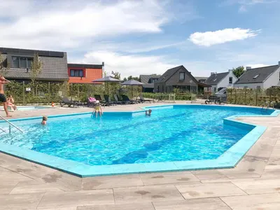 a large swimming pool with people in the water at Villa aan 't Wiel op Recreatiepark De Wielen in Sint Maarten