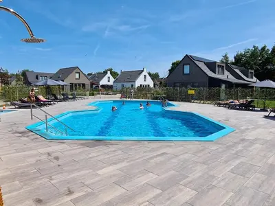 a group of people in a swimming pool at Bungalow 40 op Recreatiepark De Wielen in Sint Maarten
