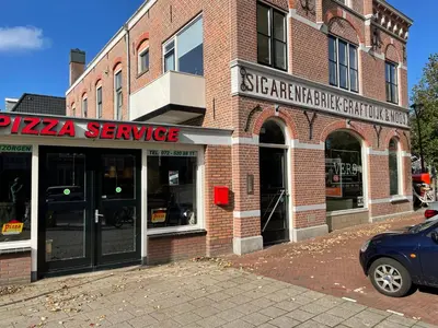 a brick building with a pizza service sign on it at City room in Alkmaar