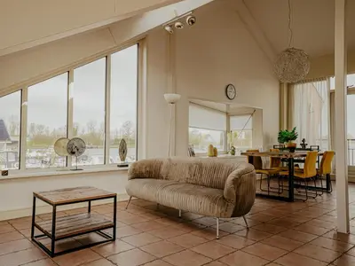 a living room with a couch and a table at Penthouse in Uitgeest