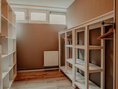 a walk in closet with white shelves at Woonark De Woude in Uitgeest