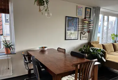 a living room with a wooden table and a couch at Lovely City Center Apartment in Alkmaar