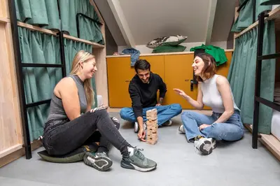 a group of people sitting on the floor in a room at The Bee Hostel in Amsterdam